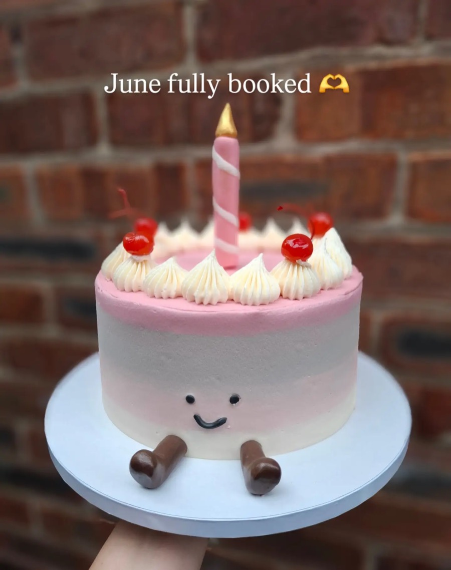 Pink cake with a smiley face and strawberries